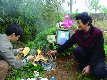 ■ 清明節(jié),倪桃蓉及兒子在張遠(yuǎn)發(fā)墳前心情復(fù)雜